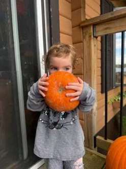 A child holding an autumn pumpkin